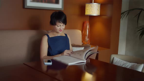 Happy Woman Sitting on Sofa and Leafing Through Magazine, Studies Trends alt