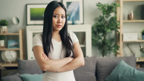 Portrait of Upset Asian Girl Looking at Camera, Making Sad Face and Expressing Negative Emotions alt