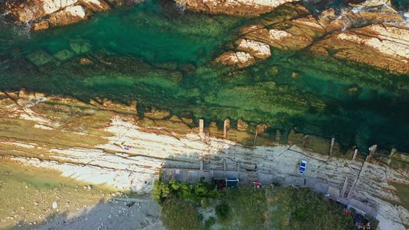 Top View of Rocky Coastline Down Blue Sea Deep White Cliffs alt