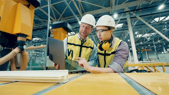 Two Factory Workers are Inspecting a Fiberglass Frame alt
