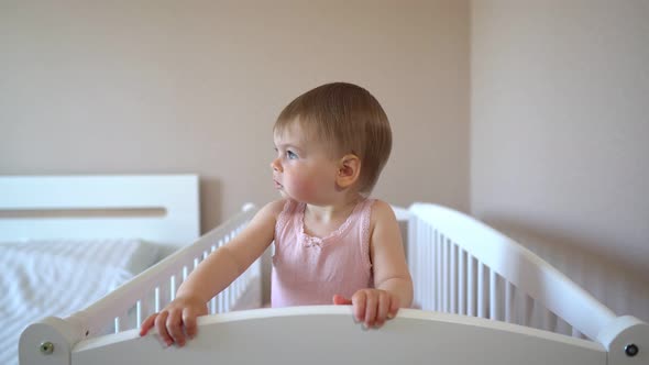 Toddler in a Crib Smiling. Cute Baby Looks at the Camera. Kindergarten.