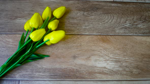 Bouquet of Yellow Tulips on a Background of Dark Wooden Boards