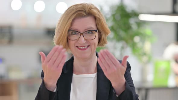 Portrait of Old Businesswoman with Pointing and Inviting alt