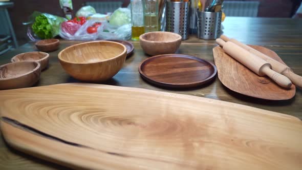 Kitchen Table with Wooden Utensils Cutting Boards and Rolling Pins alt