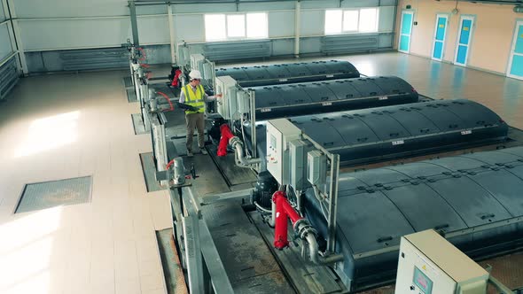 Wastewater Operator Monitoring a Sewage Treatment System Using His Laptop alt