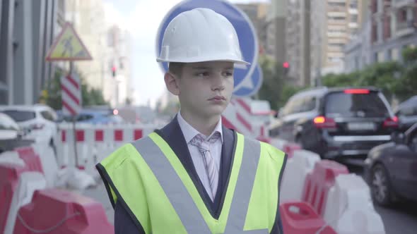 Portrait Cute Little Boy Wearing Business Suit and Safety Equipment and Constructor Helmet Standing alt