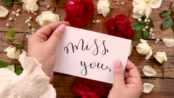 Hands bring closer to a camera MISS YOU card alt