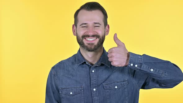 Young Man Showing Thumbs Up, Yellow Background alt