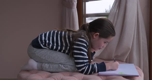 A Little Girl Drawing with Pencils at Home