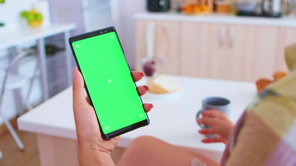 Woman Holding Portable Phone with Green Screen alt