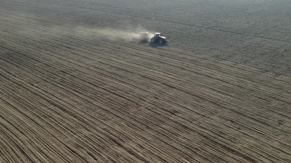 Unmanned Tractor with a Sowing Unit Works on Arable Land alt
