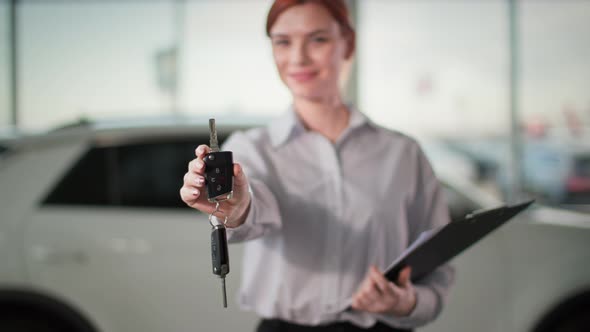 Car Purchase Young Woman Holding Automobile Keys in Her Hands in Auto Center Closeup