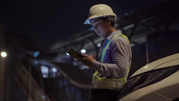 Civil engineer work inspecting architect drawing on construction site.