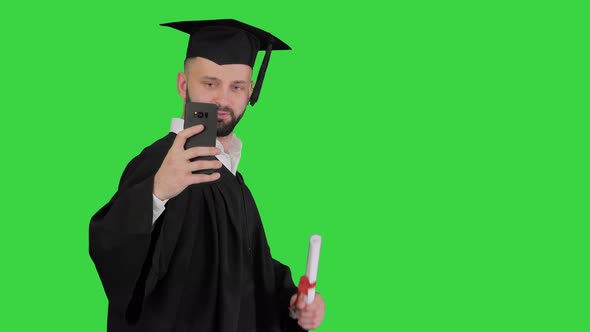 Man Wearing the Graduation Robe Walking and Taking Selfie with Diploma on a Green Screen, Chroma Key alt