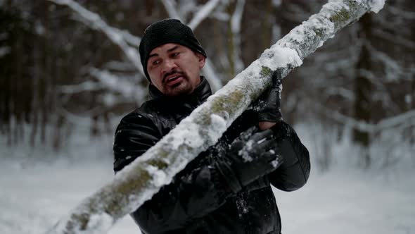 Strong Man is Lifting Log in Winter Forest Training Alone in Nature Keeping Fit alt