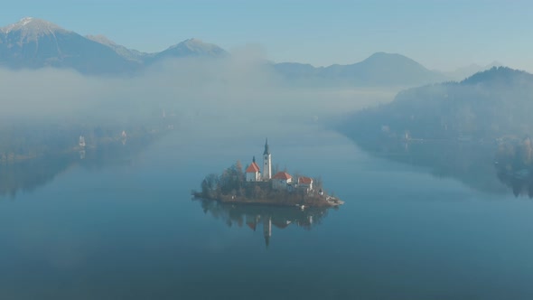 Drone shot of Lake Bled, Slovenia, on a beautiful foggy morning in spring. alt