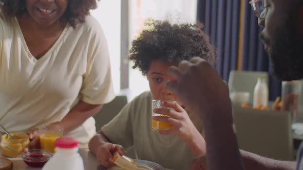 African American Family Eating Breakfast and Talking alt