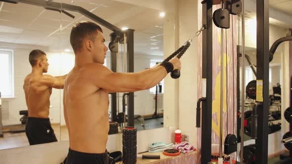 A Bodybuilder in the Gym and Does a Horizontal Pull to the Chest on the Crossover Simulator for the alt