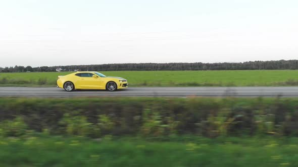 Yellow Sports Car Moving on the Country Road alt