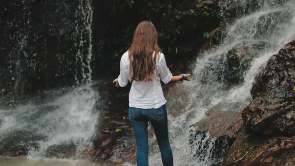 Woman Tourist Raise Hands To Splashing Waterfall alt