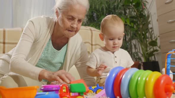 Senior Woman and Little Grandson Playing with Toys Together