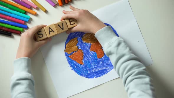 Child Putting Save Word and Heart Sign on Planet Painting alt