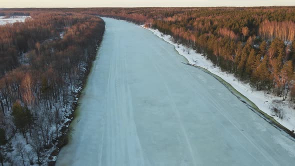 Romantic Winter Landscape with Frozen River at Sunset Aerial View alt