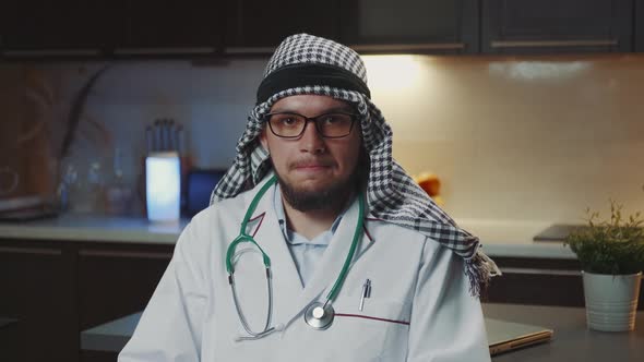 Arab Doctor with Kandora Giving Interview to the Camera From Home alt