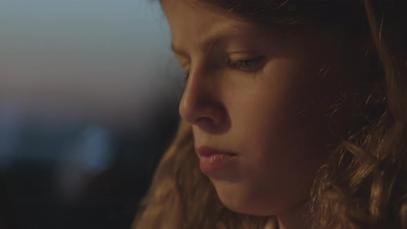 Young Girl Concentrating On Smartphone At Dusk alt