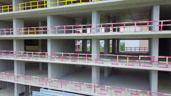 Drone rises up the floors of a multi-storey building under construction alt