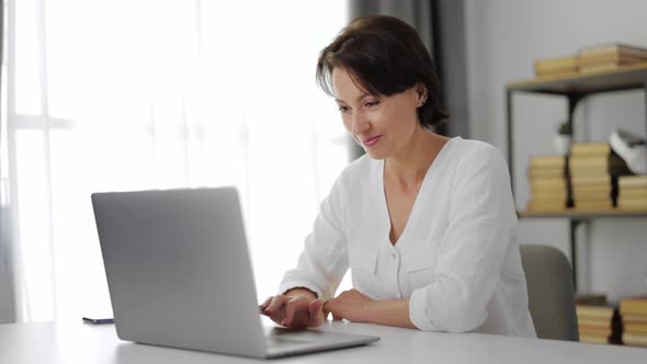Woman Browsing Internet on Laptop