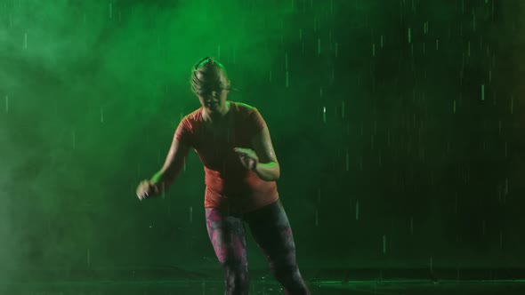 Energetic Cheerful Woman Practicing Capoeira on Smoky Dark Studio Background. The Athlete Trains in alt