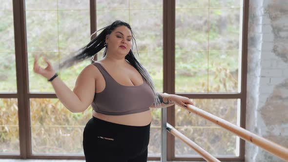Happy Body Positive Fat Woman with Dreadlocks Doing Stretching in the Gym alt