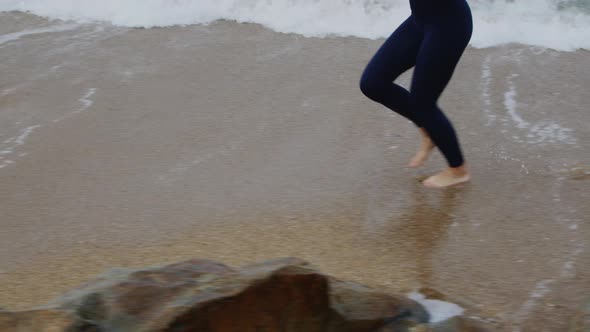 Slim Female Legs Running On Beach
