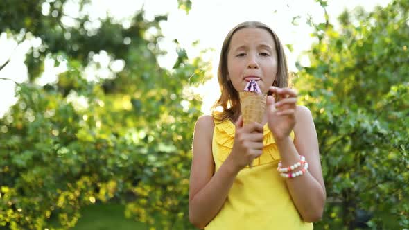 Cute girl with braces eating italian ice cream cone smiling while resting