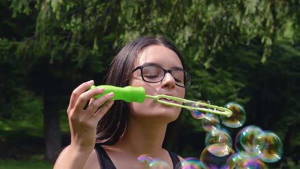 Teenage Girl Blowing Soap Bubbles in Summer