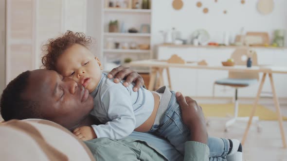 Loving Dad Patting on Back Sleeping Toddler alt
