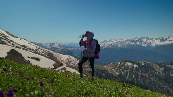 Girl Hiker in the Mountains Having a Drink alt