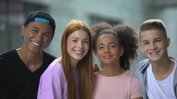 Young Multiethnic Friends Hugging and Smiling at Camera, Memory Photo, School alt