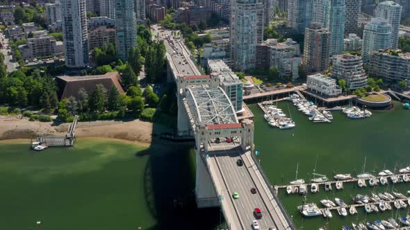 Traffic Driving At Four-lane Burrard Bridge With Moored Boats In Marina By False Creek - Reveal Shot alt