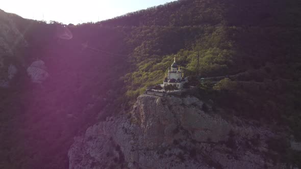 White Church Stands High in the Mountains in the Rays of Sunlight