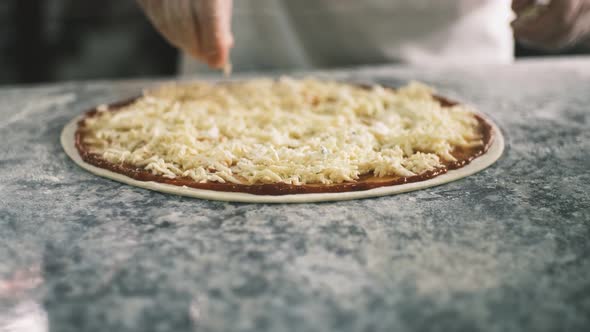 Close Up for Cook's Hands Putting Cheese on the Pizza Four Cheeses alt