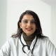 Indian Female Doctor in a White Coat with a Stethoscope Communicates with the Viewer Directly Into