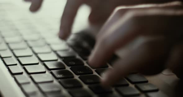 Woman typing at a laptop keyboard