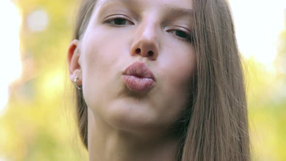 Beautiful young woman kissing. Outdoor shoot