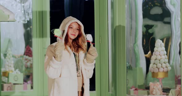 Winter Happy Woman with Christmas Candy Posing Outdoor on Confectionery Shop Background alt