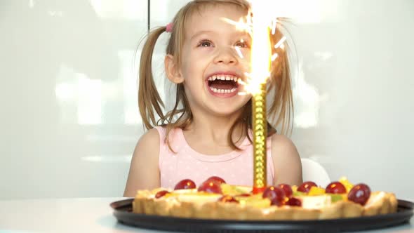 Girl Laughs Smiles and Looks at Burning Fireworks in Cake