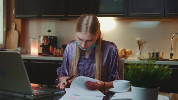 Woman in Pajama and with Medical Mask Signing Documents alt
