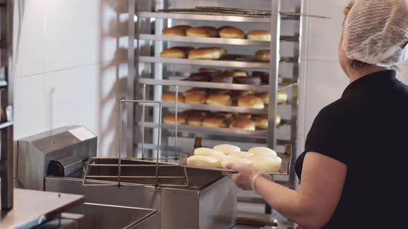 The Woman Chef Is Turning the Donut Bases on Another Side Before Frying alt