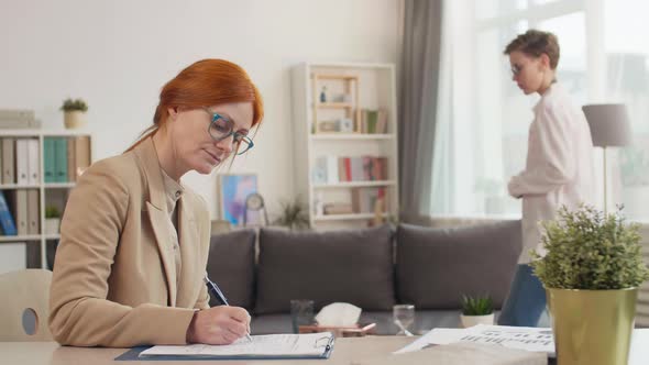 Female Red-Haired Therapist Filling Questionnaire alt